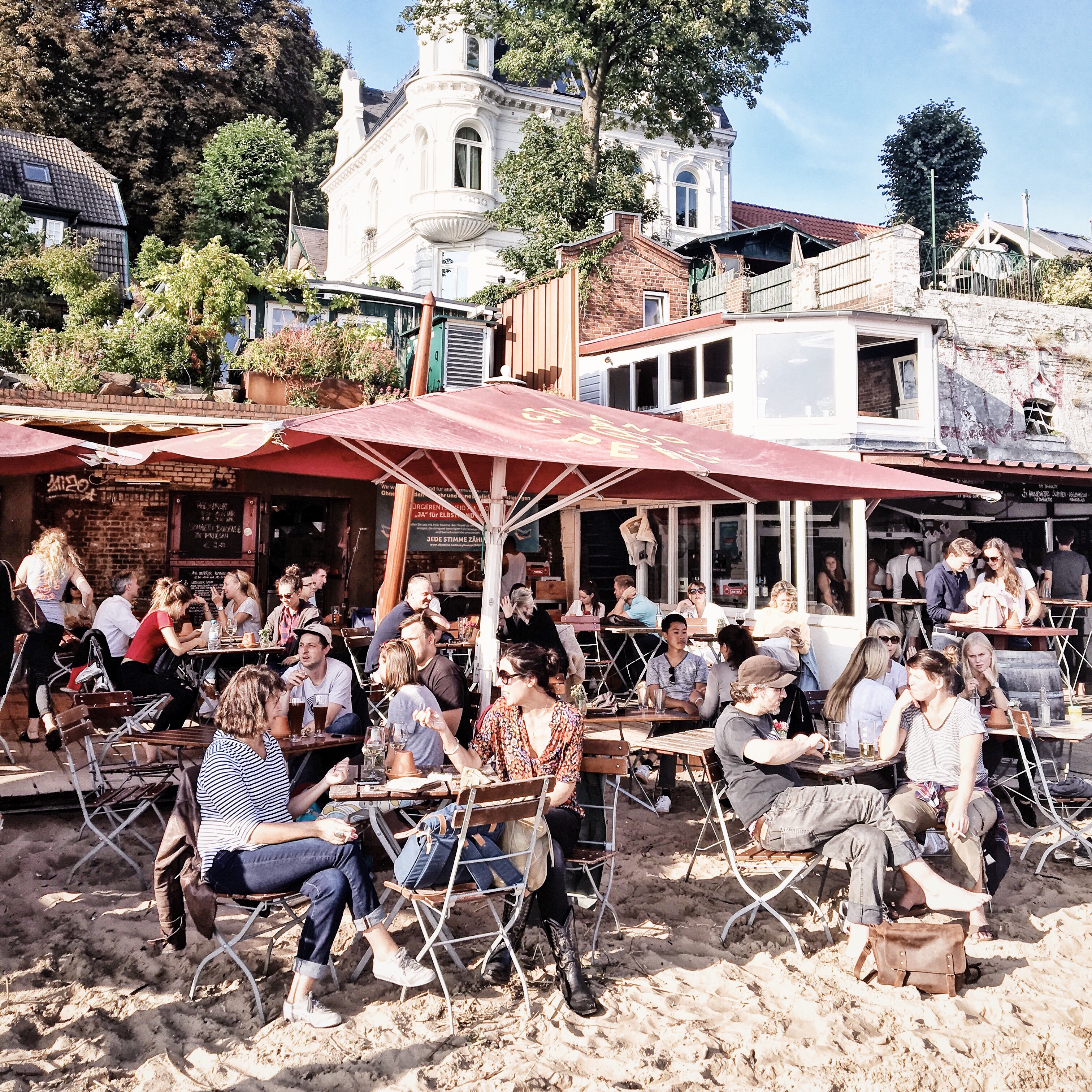 Menschen in der Strandperle, einer Bar am Elbstrand von Hamburg